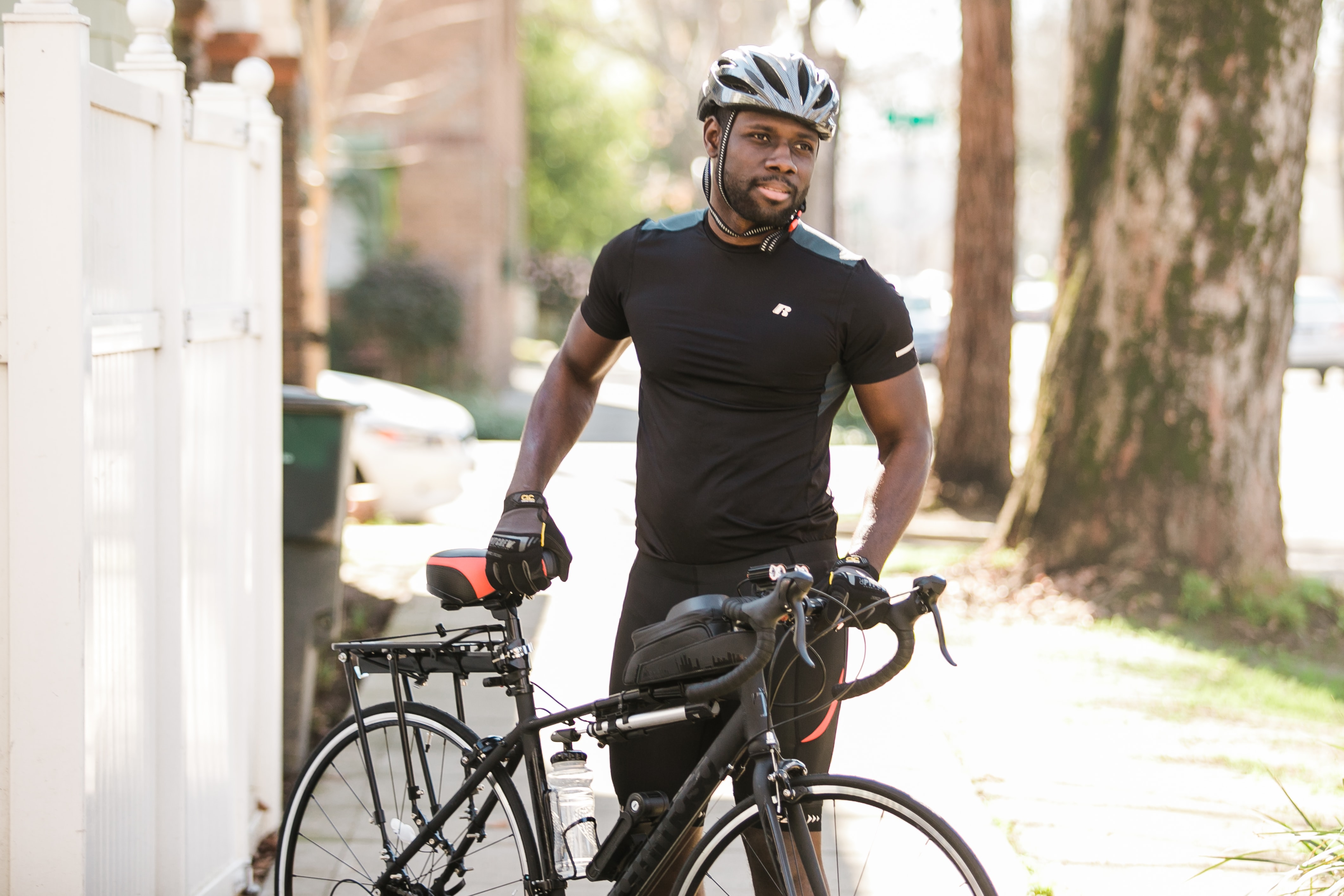 man cyclist in helmet posing with bicycle