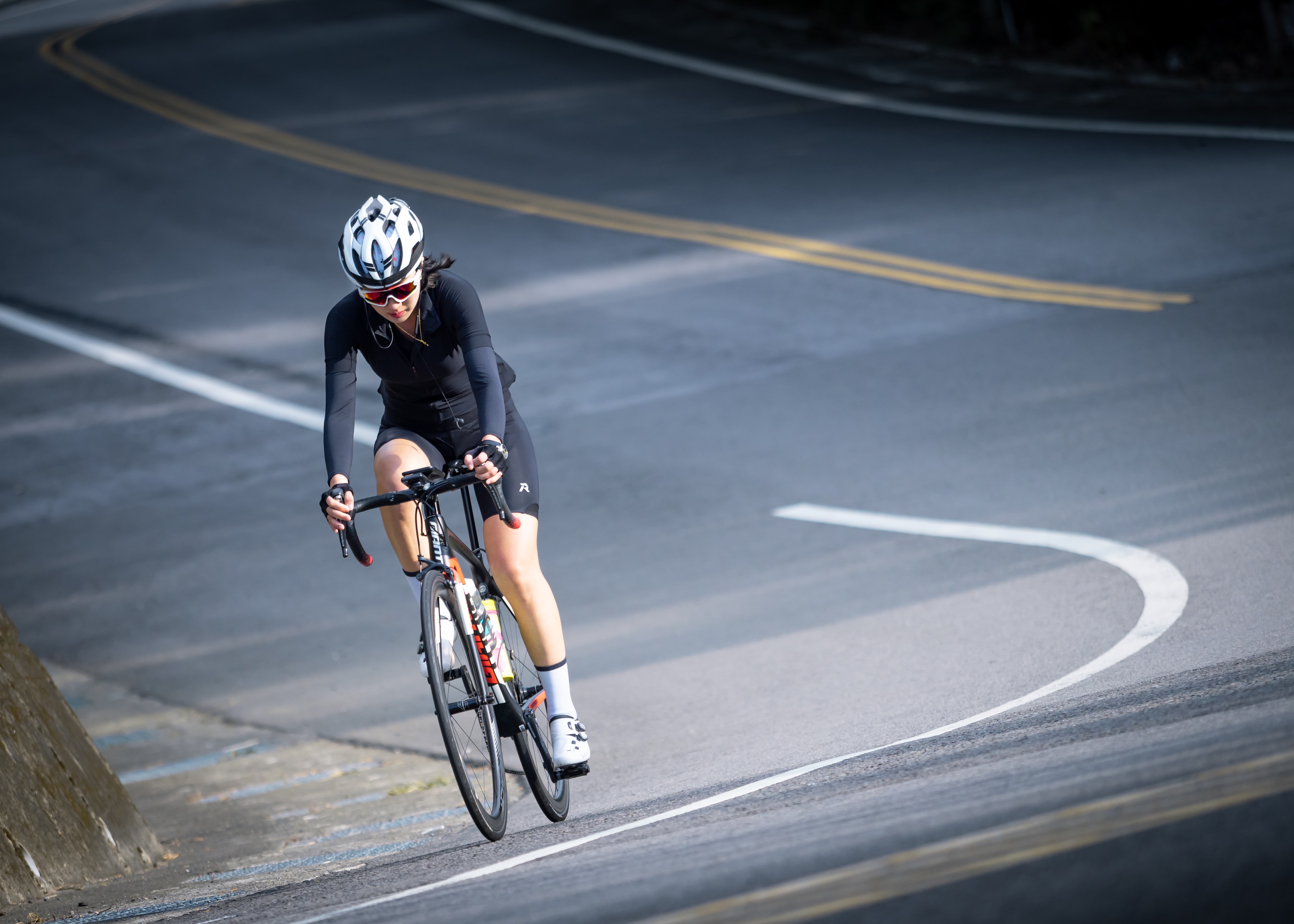 a woman riding in her riding outfit going around a bend in the road